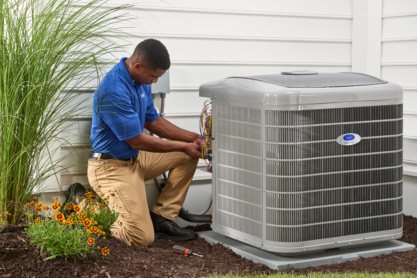 Technician servicing an outdoor HVAC unit Technician servicing an outdoor HVAC unit
